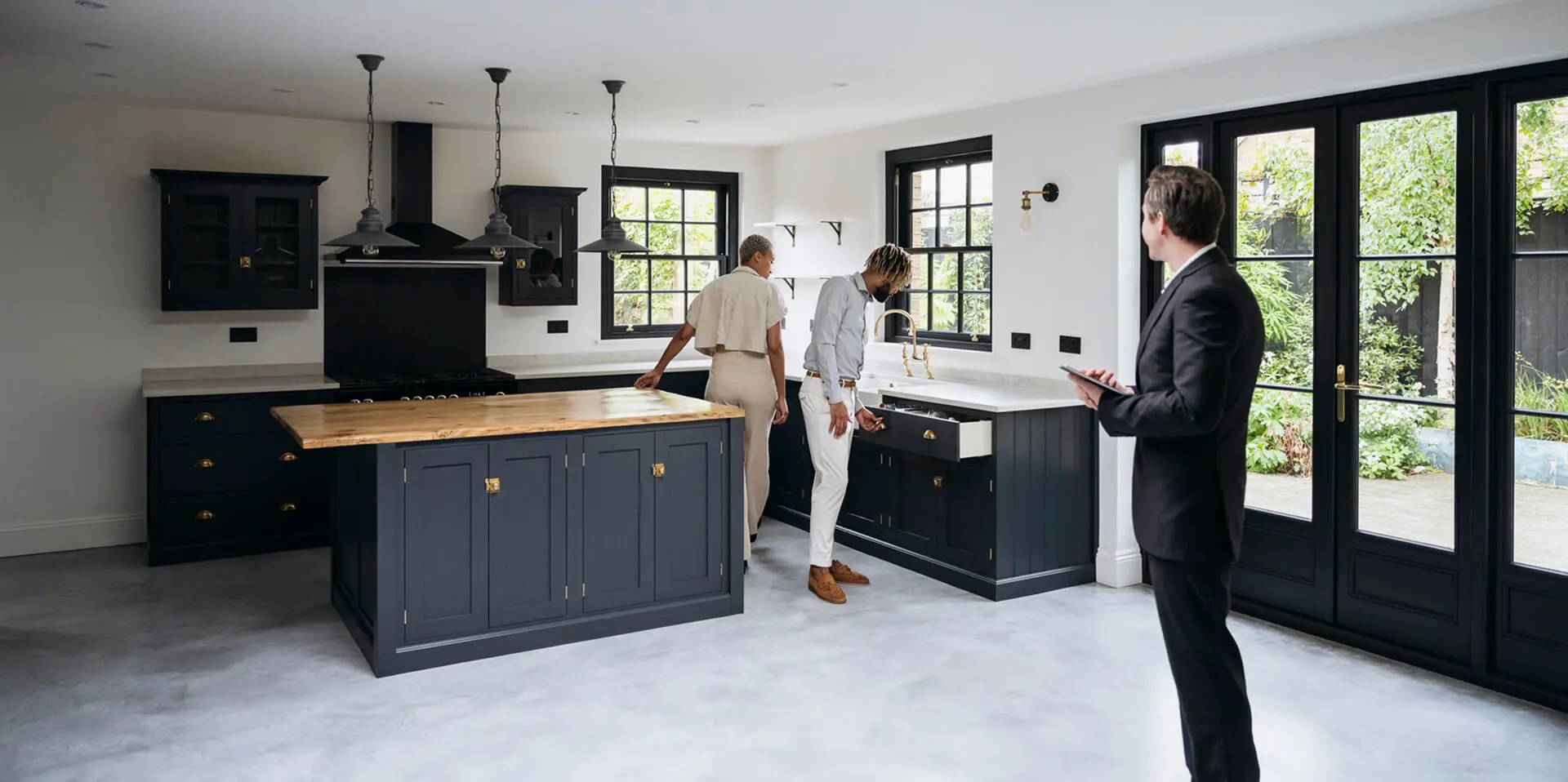 People viewing a modern kitchen interior.