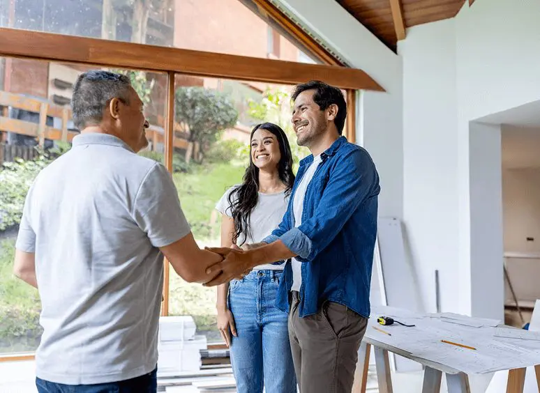 People shaking hands in a bright room.