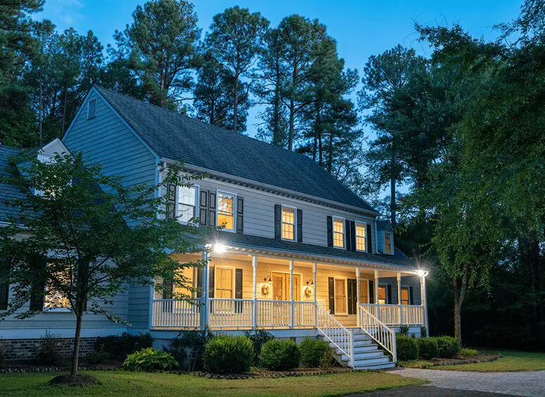 Colonial house with porch at dusk.